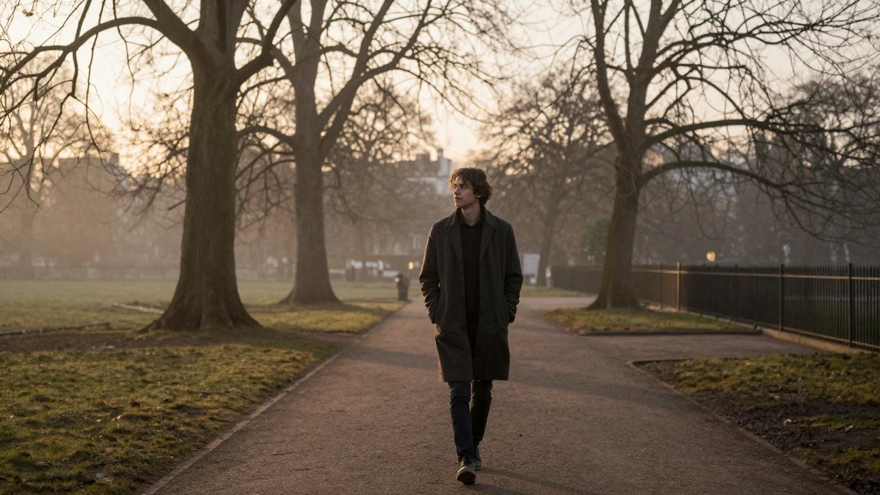 A person walking alone in a quiet London park at dusk, looking reflective and at peace.