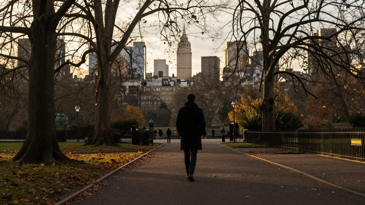 A person walking alone in Hyde Park at sunset, relaxed and surrounded by falling leaves.