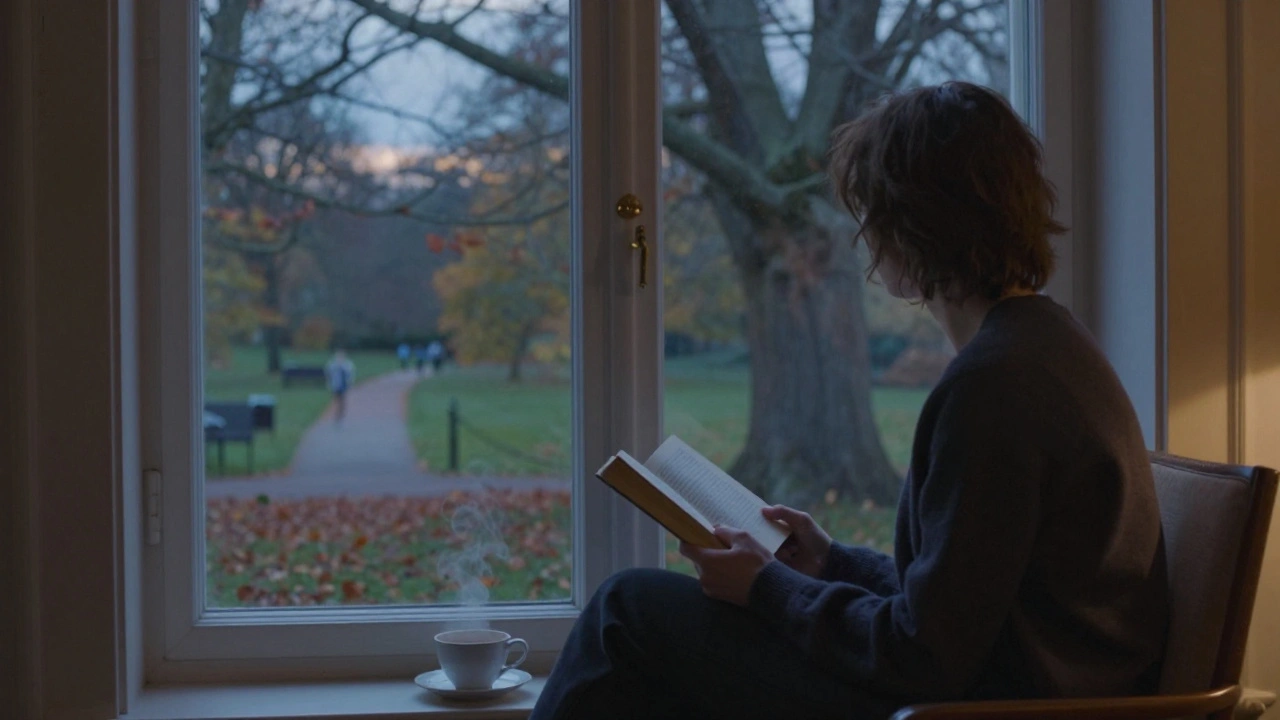Someone reading by a window with a view of a peaceful London park at dusk.