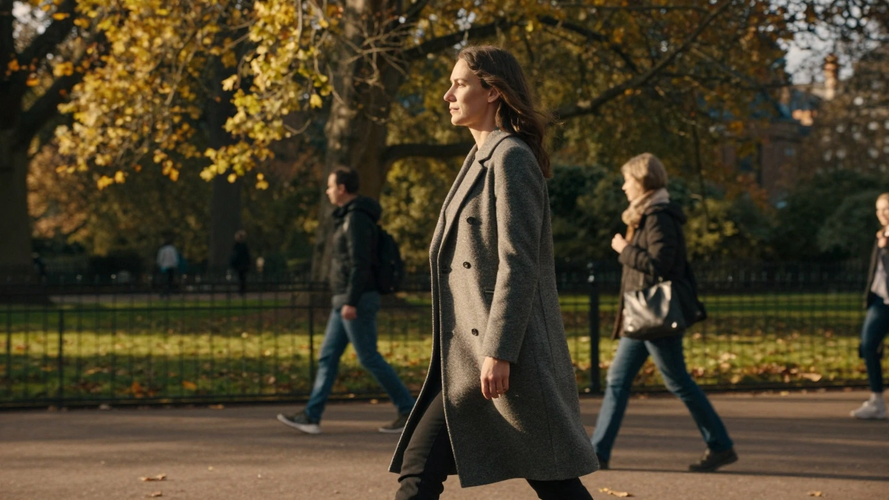A woman walking confidently through Hyde Park in golden afternoon light.