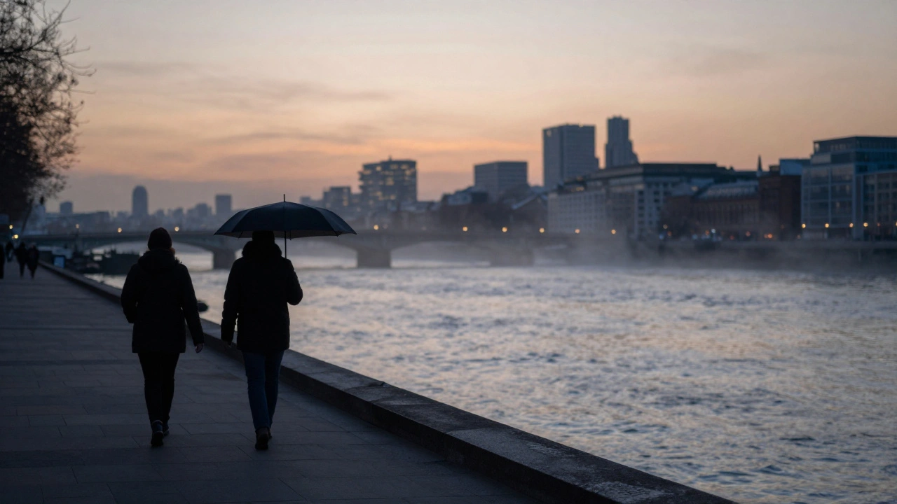 Two distant figures walking along the Thames at dusk under a soft twilight sky.