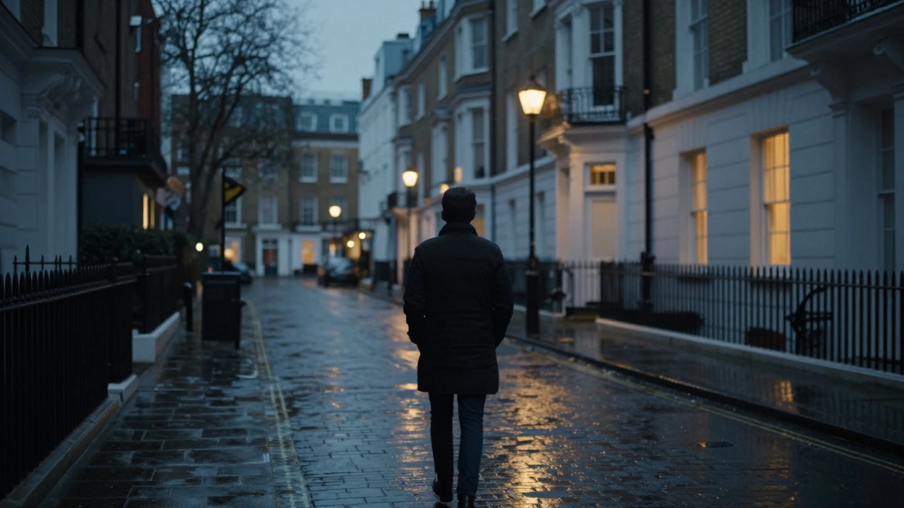 A lone person walking down a quiet London street at dusk, surrounded by warm window lights.